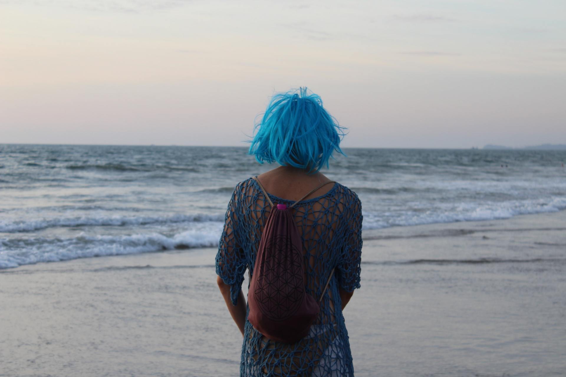 A young girl with blue hair on the beach