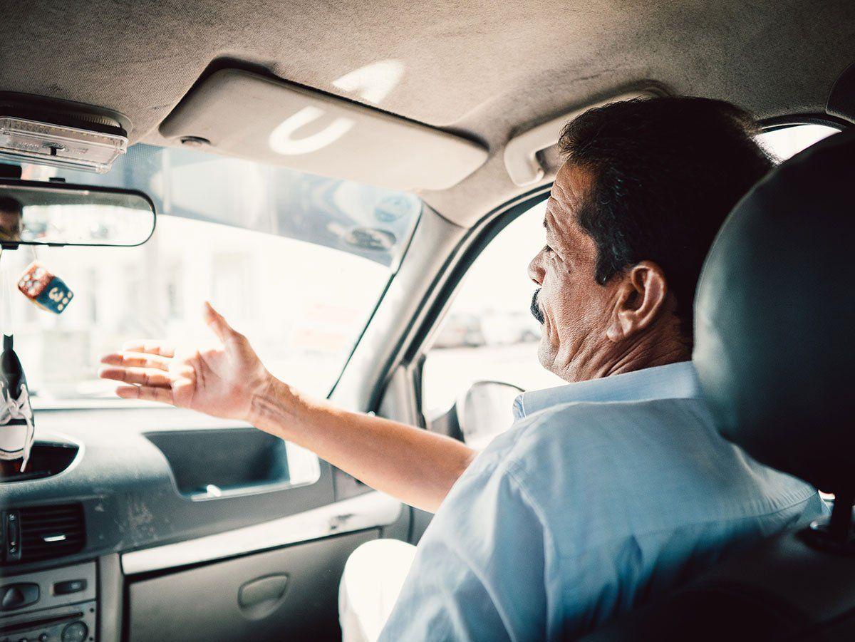 A local tour guide in the front seat of a car