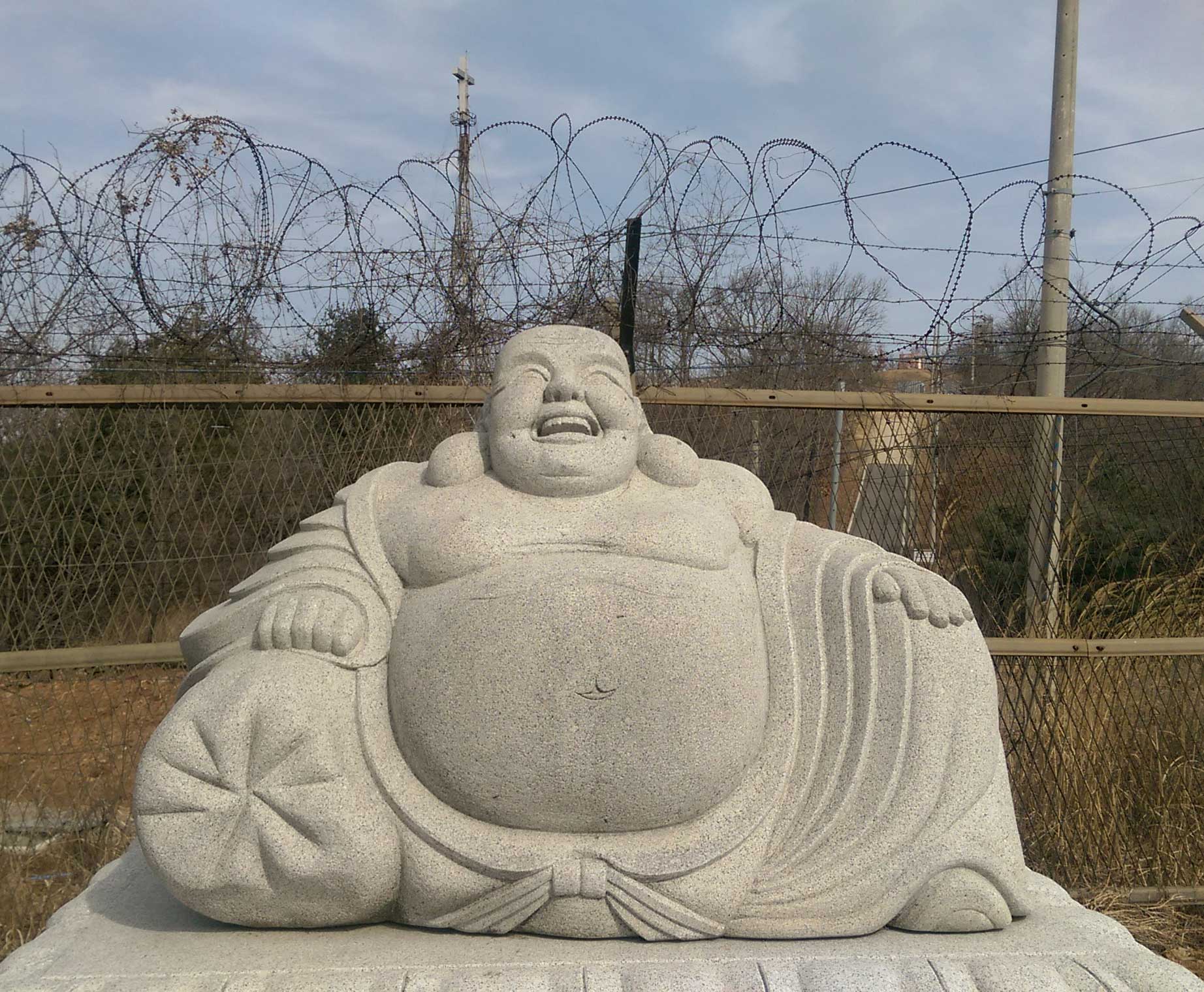 Buddah in front of barb wire fence at the DMZ, South Korea