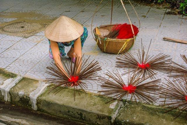Woman drying incense sticks on the street in Vietnam